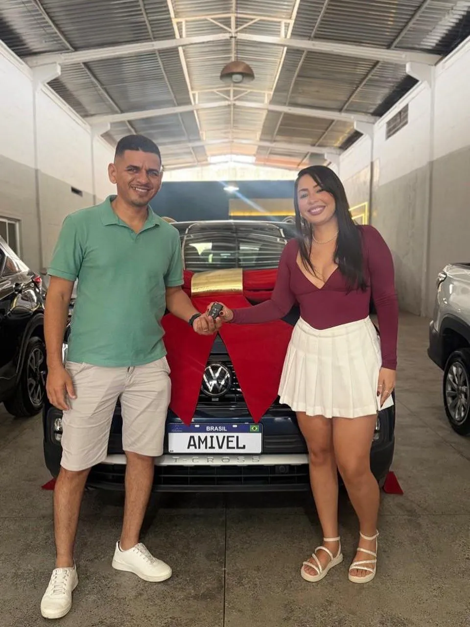 Clientes recebendo a chave de um carro na Amivel